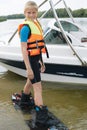 Sportin child riding on a wakeboard on the lake.