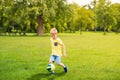 Sporting boy plays football in sunny park Royalty Free Stock Photo