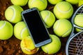 Sporting essentials Tennis balls and a racket, with a mobile phone nearby Royalty Free Stock Photo