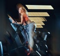 Sportive blonde woman working out on an exercise bike in modern fitness center. Fitness lifestyle in sport club. Royalty Free Stock Photo
