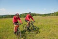 Sportive couple riding bike in summer meadow