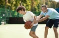 Sportive dad teaching his son how to play basketball Royalty Free Stock Photo