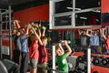 A sportive family with children in the gym is engaged with dumbbells