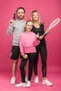 sportive family holding tennis rackets and ball, while child showing thumb up, isolated