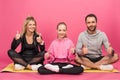 sportive family showing thumbs up while sitting on fitness mat, isolated