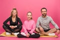 sportive family sitting on fitness mat, isolated