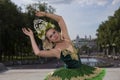 Sportive Female Ballet Dancer in Green Tutu Dress Standing With Hands Lifted Against City View Outdoor
