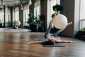 Fit woman training with exercise ball on yoga mat in fitness studio Royalty Free Stock Photo