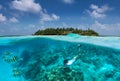 Sportive girl snorkels in turquoise waters over a coral reef in the Maldives