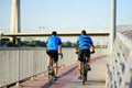 Sportive men cycling by Ada Bridge over the Sava river in Belgrade, Serbia, on hot summer day. Nice sport for active people.