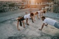 Group of athletic young people, friends in sportswear doing exercises. Sport outdoors Royalty Free Stock Photo