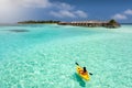 Sportive woman canoeing over the waters of the Maldives Royalty Free Stock Photo