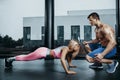 Sportive woman doing plank exercise training back and press muscles with trainer. Sport fitness workout strength power Royalty Free Stock Photo