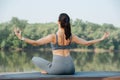 Sportive woman doing yoga outdoors in a beautiful spot on a riverside