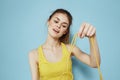 Sportive woman holding a skipping rope yellow tank top exercise gymnastics blue background Royalty Free Stock Photo