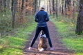 Sportive woman training her dog to sit Royalty Free Stock Photo