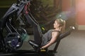 Sportive woman using weights press machine for legs. Gym. Royalty Free Stock Photo