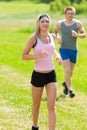 Sportive young couple jogging meadows sunny summer Royalty Free Stock Photo
