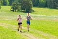 Sportive young couple jogging meadows sunny summer Royalty Free Stock Photo