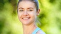 Sportive young woman blonde in blue tracksuit turns head and looks straight with cheerful smile