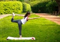 Sportive young woman stretching, doing exercises balancing