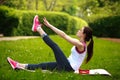 Sportive young woman stretching, doing fitness exercises in park Royalty Free Stock Photo