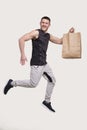 Sportman Holding Food Bag. Man with Paper Bag in Hands. Healthy Eating, Healthy Food, Sport Concept. Sport man Jumping Royalty Free Stock Photo