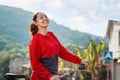 Sports and activity. Portrait of a smiling, happy woman in red sportswear standing next to a Bicycle. In the background, a street Royalty Free Stock Photo