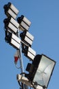 Sports arena floodlights stadium lights against blue day sky background