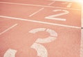 Sports, athletics and number on race track in stadium for training, sprint and running start position. Texture, ground