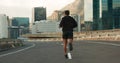 Sports, back and running in morning on city, street and bridge for fitness, workout and marathon training. Athlete, man