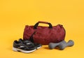 Sports bag and gym equipment on yellow background Royalty Free Stock Photo