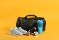 Sports bag and gym equipment on yellow background Royalty Free Stock Photo
