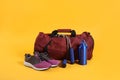 Sports bag and gym equipment on yellow background Royalty Free Stock Photo