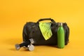 Sports bag and gym equipment on yellow background Royalty Free Stock Photo