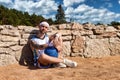 Sports and basketball concept. Man with basketball ball in arm sitting in desert looking at camera smiling outdoors Royalty Free Stock Photo