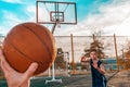 Sports and basketball. A man`s hand holds a basketball for submission. In the background, a teenager preparing to catch a ball.