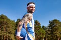 Sports and basketball. Young man with basketball in arm looking at camera smiling at blue sky outdoors Royalty Free Stock Photo