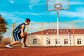 Sports and basketball. A young teenager in a dark blue tracksuit plays basketball on the school Playground. Bottom view from the