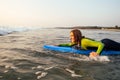 Sports beautiful woman in a diving suit lying on a surfboard waiting for a big wave .surf girl in a wetsuit surfing in Royalty Free Stock Photo