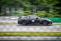 Black fast sports japanese car drives along a racing circuit.