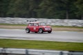 Red old sports car Mini Cooper drives along a racing circuit. Royalty Free Stock Photo