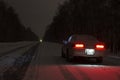 Sports car at night on a winter icy road in the absence of traffic