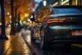 Sports car in the parking lot in the autumn evening park. Electric car with rear light on close up. Royalty Free Stock Photo