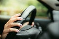 Sports car steering wheel, hands of a young girl with purple nail polish Royalty Free Stock Photo