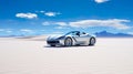 sports car in a stunning desert landscape with expansive blue skies above. Royalty Free Stock Photo