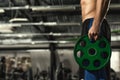 Shirtless muscular man with toned athletic body holding barbell weight plate