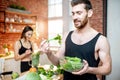 Sports couple eating healthy vegetarian food on the kitchen