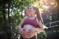 Couple standing in the park and touch the stomach Royalty Free Stock Photo