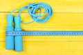 Sports equipment in cyan color. Measuring tape and jump rope Royalty Free Stock Photo